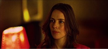 Movie still from “Fear X” (2003), directed by Nicolas Winding Refn – A person with long brown hair; Close Up shot, Over the shoulder angle