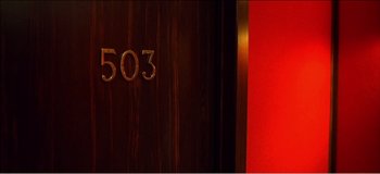 Movie still from “Fear X” (2003), directed by Nicolas Winding Refn – The door of a building with the number 5 0 3 on it's side; Extreme Close Up shot, High angle