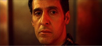 Movie still from “Fear X” (2003), directed by Nicolas Winding Refn – A man's face in a dimly - lit room; Close Up shot, Low angle