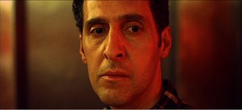Movie still from “Fear X” (2003), directed by Nicolas Winding Refn – A man's face in a dimly - lit room; Close Up shot, Low angle