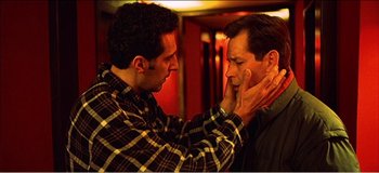 Movie still from “Fear X” (2003), directed by Nicolas Winding Refn – A man touching another man's face with his hands; Close Up shot, Low angle
