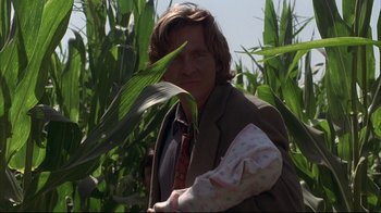 Movie still from “Fearless” (1993), directed by Peter Weir – A man holding a baby in his arms in a corn field; Medium shot, Over the shoulder angle