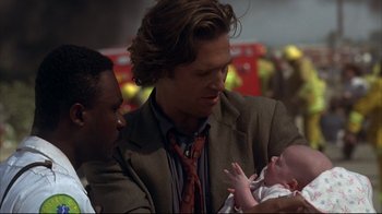 Movie still from “Fearless” (1993), directed by Peter Weir – A man in a suit holding a baby in his arms; Close Up shot, Over the shoulder angle