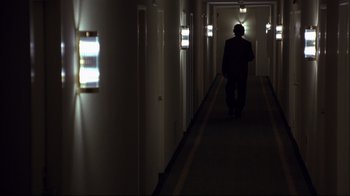 Movie still from “Fearless” (1993), directed by Peter Weir – A man walking down a long hallway in a building; Wide shot, Low angle