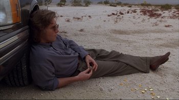 Movie still from “Fearless” (1993), directed by Peter Weir – A man sitting on the ground in the desert; Wide shot, Low angle