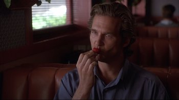 Movie still from “Fearless” (1993), directed by Peter Weir – A man sitting in front of a window eating a piece of food; Close Up shot, Over the shoulder angle