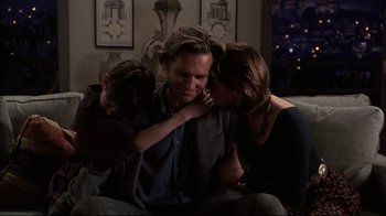 Movie still from “Fearless” (1993), directed by Peter Weir – A couple of people that are hugging a man; Medium shot, Over the shoulder angle