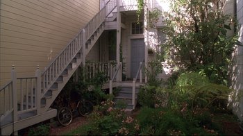 Movie still from “Fearless” (1993), directed by Peter Weir – A bicycle parked in front of a house with stairs; Wide shot, High angle