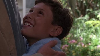 Movie still from “Fearless” (1993), directed by Peter Weir – A person holding a child; Close Up shot, Low angle