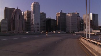 Movie still from “Fearless” (1993), directed by Peter Weir – A man riding a bike down the middle of a road; Extreme Wide shot, High angle