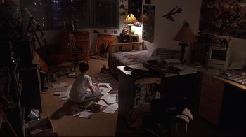 Movie still from “Fearless” (1993), directed by Peter Weir – A boy sitting on the floor of a room with papers scattered on the floor; Wide shot, High angle