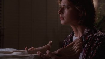 Movie still from “Fearless” (1993), directed by Peter Weir – A woman sitting in front of a window with her hands clasped together; Close Up shot, Low angle