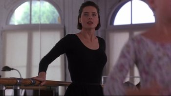 Movie still from “Fearless” (1993), directed by Peter Weir – A woman in a black dress standing in a room; Medium shot, Low angle
