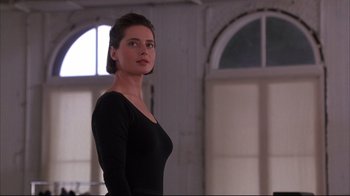 Movie still from “Fearless” (1993), directed by Peter Weir – A woman in a black dress standing in front of a window; Medium shot, Low angle