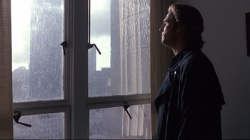 Movie still from “Fearless” (1993), directed by Peter Weir – A man standing in front of a window looking outside; Close Up shot, Low angle