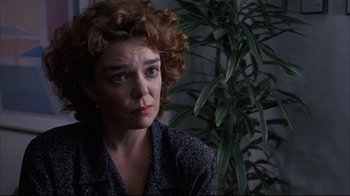 Movie still from “Fearless” (1993), directed by Peter Weir – A person sitting in a room near a plant; Close Up shot, Over the shoulder angle
