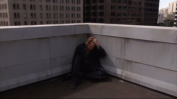 Movie still from “Fearless” (1993), directed by Peter Weir – A man sitting on the ground with his head in his hands; Wide shot, Overhead angle