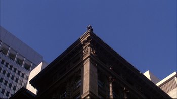 Movie still from “Fearless” (1993), directed by Peter Weir – A very tall building that has a very large building on top of it; Extreme Wide shot, Low angle