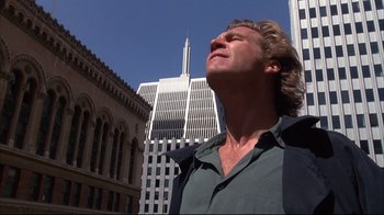 Movie still from “Fearless” (1993), directed by Peter Weir – A man standing in front of a building looking up; Close Up shot, Low angle