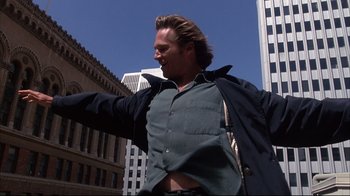 Movie still from “Fearless” (1993), directed by Peter Weir – A man standing in the street with his arms outstretched; Medium shot, Low angle