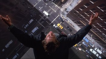 Movie still from “Fearless” (1993), directed by Peter Weir – A man standing on the side of a building looking up at the sky; Wide shot, Overhead angle