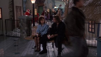 Movie still from “Fearless” (1993), directed by Peter Weir – A couple of people sitting on top of a wooden bench; Wide shot, Over the shoulder angle