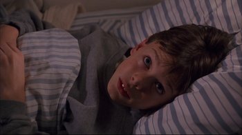 Movie still from “Fearless” (1993), directed by Peter Weir – A boy laying in a bed with his mouth wide open; Close Up shot, High angle
