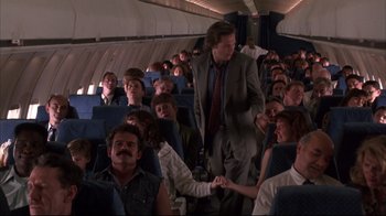Movie still from “Fearless” (1993), directed by Peter Weir – A group of people sitting on a plane holding hands; Wide shot, High angle