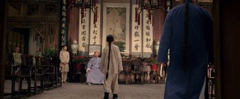 Movie still from “Fearless” (2006), directed by Ronny Yu – A man and a woman are standing in front of a wall with calligraphy on it; Wide shot, Over the shoulder angle
