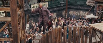Movie still from “Fearless” (2006), directed by Ronny Yu – A man jumping over a wooden fence in front of a crowd of onlookers; Wide shot, Low angle