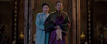 Movie still from “Fearless” (2006), directed by Ronny Yu – Two women standing next to each other in front of a wall; Medium shot, Low angle
