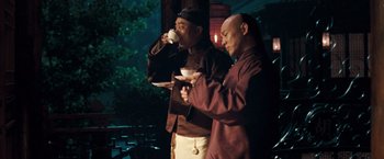 Movie still from “Fearless” (2006), directed by Ronny Yu – A couple of men standing next to each other holding cups; Medium shot, Low angle