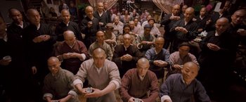 Movie still from “Fearless” (2006), directed by Ronny Yu – A large group of bald men sitting in a room; Wide shot, High angle
