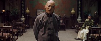 Movie still from “Fearless” (2006), directed by Ronny Yu – A man standing in front of a wall; Medium shot, Low angle