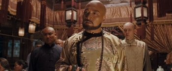 Movie still from “Fearless” (2006), directed by Ronny Yu – A man with a bald head is holding a cell phone; Medium shot, Over the shoulder angle