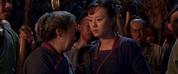 Movie still from “Fearless” (2006), directed by Ronny Yu – A woman and a man are standing in front of a group of people; Medium shot, Over the shoulder angle