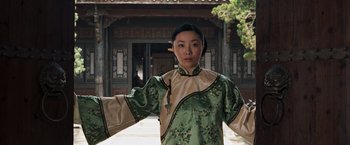 Movie still from “Fearless” (2006), directed by Ronny Yu – A woman in a green and beige outfit standing outside; Medium shot, Low angle