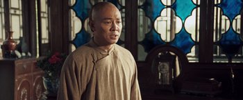 Movie still from “Fearless” (2006), directed by Ronny Yu – A man in a tan shirt and a brown robe; Medium shot, Over the shoulder angle