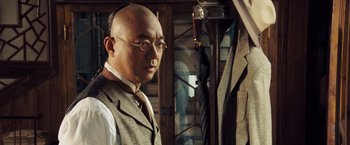 Movie still from “Fearless” (2006), directed by Ronny Yu – A man in a suit and tie standing in front of a mirror; Close Up shot, Over the shoulder angle