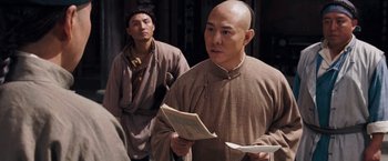 Movie still from “Fearless” (2006), directed by Ronny Yu – A man in a monk's outfit is holding a book; Medium shot, Over the shoulder angle