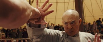 Movie still from “Fearless” (2006), directed by Ronny Yu – A man in a white shirt is doing an action pose; Close Up shot, Low angle