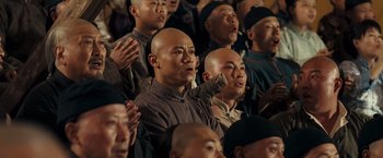 Movie still from “Fearless” (2006), directed by Ronny Yu – A group of people sitting in a room; Medium shot, Low angle