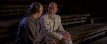 Movie still from “Fearless” (2006), directed by Ronny Yu – A man in a suit and tie sitting next to another man; Medium shot, Over the shoulder angle