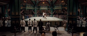 Movie still from “Fearless” (2006), directed by Ronny Yu – A group of people watching a man fight in an arena; Extreme Wide shot, High angle