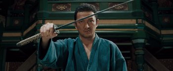 Movie still from “Fearless” (2006), directed by Ronny Yu – A man holding a sword up to his face; Close Up shot, Low angle