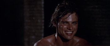 Movie still from “Fellini Satyricon” (1969), directed by Federico Fellini – A man with wet hair and a smile on his face; Close Up shot, High angle