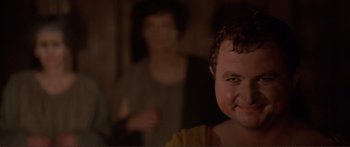 Movie still from “Fellini Satyricon” (1969), directed by Federico Fellini – A young boy smiles in front of an older woman; Close Up shot, Over the shoulder angle