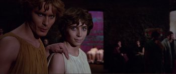 Movie still from “Fellini Satyricon” (1969), directed by Federico Fellini – A young woman with her arm around another young woman; Medium shot, Over the shoulder angle