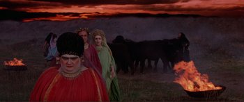 Movie still from “Fellini Satyricon” (1969), directed by Federico Fellini – A group of people standing next to a herd of cattle; Wide shot, High angle
