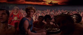 Movie still from “Fellini Satyricon” (1969), directed by Federico Fellini – A group of people sitting in front of an audience; Medium shot, High angle